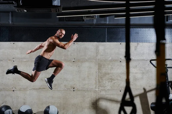 Hombre Musculoso Capturado Aire Mientras Salta Gimnasio Moderno Mostrando Atletismo —  Fotos de Stock