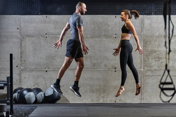 一对健康的夫妇在现代体育馆里进行各种类型的跳跃 展示他们的体能 力量和运动表现 — 图库照片
