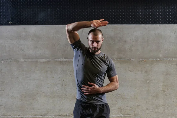 Muskularny Mężczyzna Ćwiczący Rozciąganie Ramion Mięśni Ciała Nowoczesnej Siłowni — Zdjęcie stockowe