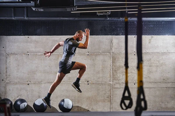 Hombre Musculoso Capturado Aire Mientras Salta Gimnasio Moderno Mostrando Atletismo —  Fotos de Stock