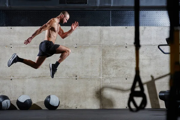 Мускулистый Человек Захваченный Воздухе Прыгает Современном Спортзале Демонстрируя Свой Атлетизм — стоковое фото