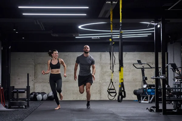 在现代体育馆里 一对健康的夫妇正在进行跑步锻炼 并以一个充满活力的开端展示他们的运动能力 — 图库照片