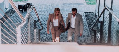 Uzun bir çalışmadan sonra modern iş çifti, evlerinin rahatlığı için birlikte yürüyorlar, profesyonel başarı ve kişisel memnuniyetin mükemmel bir karışımını oluşturuyorlar.