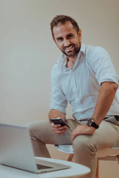 Ein Selbstbewusster Geschäftsmann Der Mit Entschlossenem Gesichtsausdruck Laptop Und Smartphone — Stockfoto