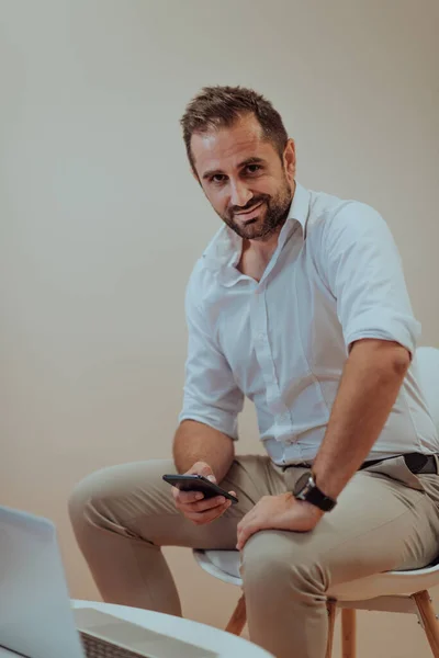 Empresário Confiante Sentado Usando Laptop Smartphone Com Uma Expressão Determinada — Fotografia de Stock