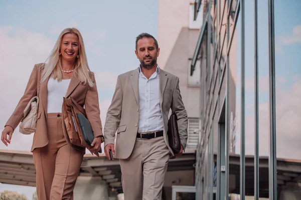 stock image Modern business couple after a long days work, walking together towards the comfort of their home, embodying the perfect blend of professional success and personal contentment