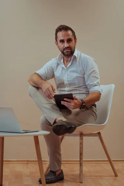 Hombre Negocios Confiado Sentado Usando Una Tableta Con Una Expresión —  Fotos de Stock