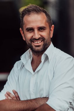 Beyaz gömlekli başarılı bir iş adamı dışarıda poz veriyor. Yüksek kalite fotoğraf