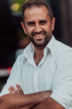 Beyaz gömlekli başarılı bir iş adamı dışarıda poz veriyor. Yüksek kalite fotoğraf
