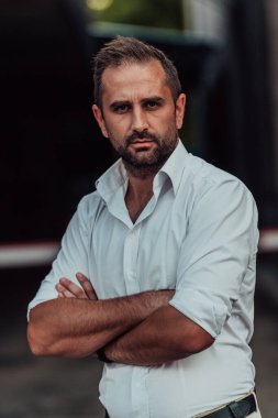 Beyaz gömlekli başarılı bir iş adamı dışarıda poz veriyor. Yüksek kalite fotoğraf