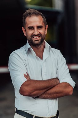 Beyaz gömlekli başarılı bir iş adamı dışarıda poz veriyor. Yüksek kalite fotoğraf