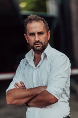 Beyaz gömlekli başarılı bir iş adamı dışarıda poz veriyor. Yüksek kalite fotoğraf