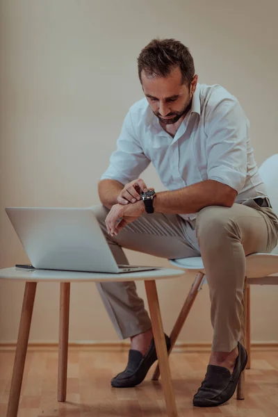 Hombre Negocios Confiado Sentado Usando Portátil Smartwatch Con Una Expresión — Foto de Stock
