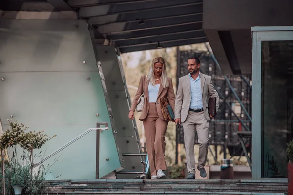 stock image Modern business couple after a long days work, walking together towards the comfort of their home, embodying the perfect blend of professional success and personal contentment