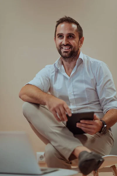 Hombre Negocios Confiado Sentado Usando Una Tableta Con Una Expresión —  Fotos de Stock
