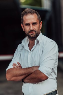 Beyaz gömlekli başarılı bir iş adamı dışarıda poz veriyor. Yüksek kalite fotoğraf