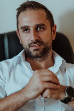 Başarılı bir işadamı yorucu bir günün ardından ofisinde oturuyor. Yüksek kalite fotoğraf