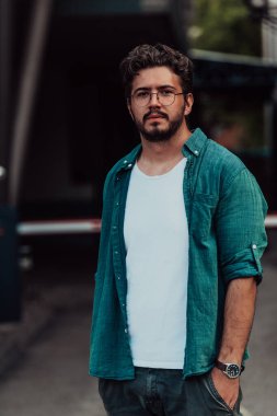 Modern bir adamın portresi, kendine güveni ve stili, açık bir arkaplanda, karizmasını ve modaya uygun tavırlarını sergiliyor.