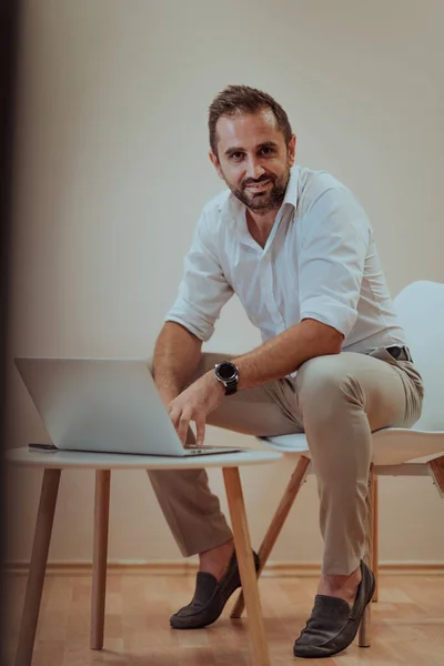 Empresário Confiante Sentado Usando Laptop Com Uma Expressão Determinada Enquanto — Fotografia de Stock