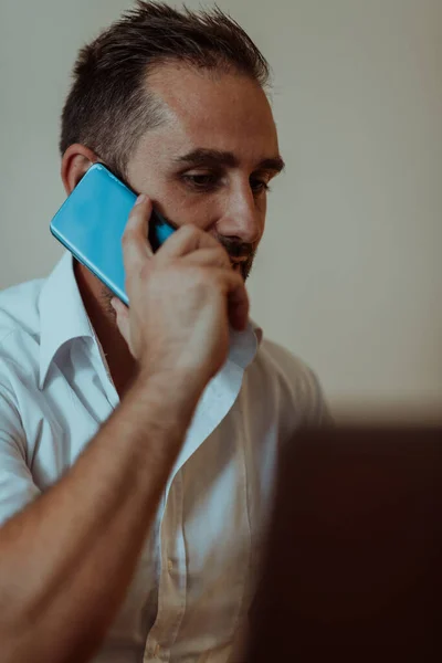 一位商人坐在办公室里用智能手机交谈 展示了他的职业举止和积极的交流 — 图库照片