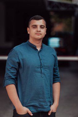 Modern bir adamın portresi, kendine güveni ve stili, açık bir arkaplanda, karizmasını ve modaya uygun tavırlarını sergiliyor.