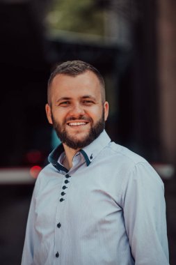 Modern bir adamın portresi, kendine güveni ve stili, açık bir arkaplanda, karizmasını ve modaya uygun tavırlarını sergiliyor.