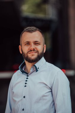 Modern bir adamın portresi, kendine güveni ve stili, açık bir arkaplanda, karizmasını ve modaya uygun tavırlarını sergiliyor.