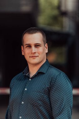 Modern bir adamın portresi, kendine güveni ve stili, açık bir arkaplanda, karizmasını ve modaya uygun tavırlarını sergiliyor.