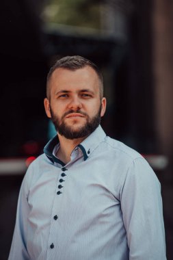 Modern bir adamın portresi, kendine güveni ve stili, açık bir arkaplanda, karizmasını ve modaya uygun tavırlarını sergiliyor.