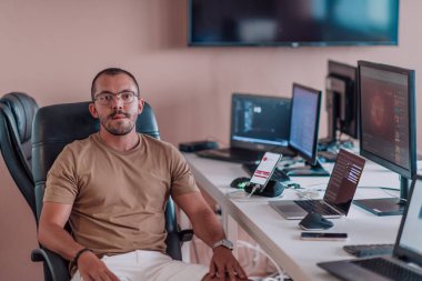 Bir programcı ofisinde otururken akıllı telefon uygulamalarını özenle test ediyor. Yüksek kalite fotoğraf