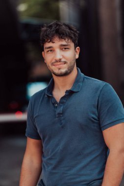 Modern bir adamın portresi, kendine güveni ve stili, açık bir arkaplanda, karizmasını ve modaya uygun tavırlarını sergiliyor.