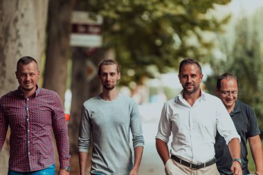 Verimli bir iş gününden sonra, bir grup farklı meslektaş modern ve doğal bir şehir ortamında sakin bir gezinti yapıyorlar..