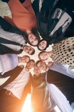 Birbirlerini sıkıca kucaklayan çeşitli iş adamları grubu birlik ve dayanışmayı sembolize ediyor.. 