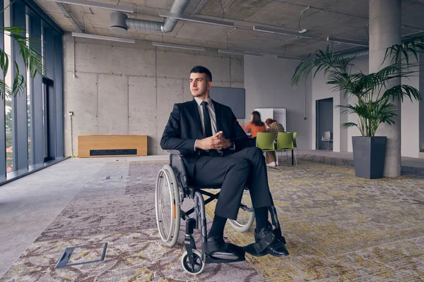 坐在轮椅上的商人值得关注 在一个充满活力的现代办公环境中 这象征着韧性和成功 — 图库照片