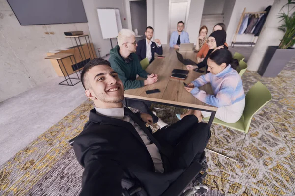 在一个现代化的办公室里 一群商人在会议期间围坐在桌旁 在他们自私自利的过程中捕捉了片刻的友谊和团队精神 — 图库照片