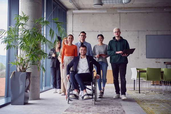 众多商人 包括坐轮椅的商人 自信地走在一起 通过一个现代宽敞的办公室 体现了合作 包容和团结的力量 — 图库照片