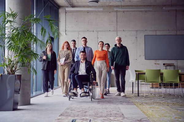 众多商人 包括坐轮椅的商人 自信地走在一起 通过一个现代宽敞的办公室 体现了合作 包容和团结的力量 — 图库照片