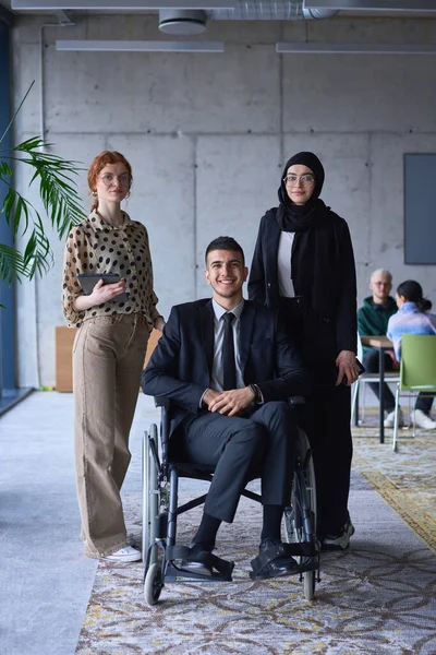Biznesmen Niepełnosprawny Wózku Inwalidzkim Jest Otoczony Przez Wspierających Kolegów Nowoczesnym — Zdjęcie stockowe