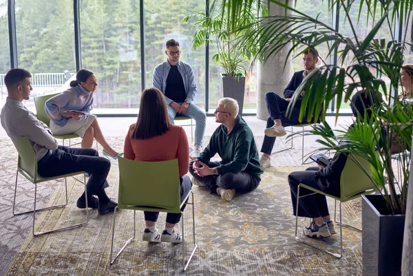一个人坐在圈子的中心 热情洋溢地与同事们分享他的商业理念 在一个充满活力和吸引人的工作场所营造一种协作和创新的氛围 — 图库照片