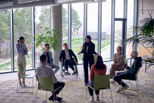 A business hijab woman in the center of a circle, passionately sharing his business ideas with his colleagues, fostering an atmosphere of collaboration and innovation in a dynamic and engaging
