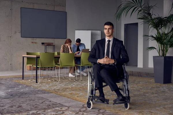 坐在轮椅上的商人值得关注 在一个充满活力的现代办公环境中 这象征着韧性和成功 — 图库照片