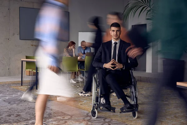 Biznesmen Wózku Inwalidzkim Nowoczesnym Biurze Otoczony Przez Kolegów Którzy Przedstawiani — Zdjęcie stockowe