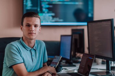 Bir programcı ofisinde otururken akıllı telefon uygulamalarını özenle test ediyor. Yüksek kalite fotoğraf