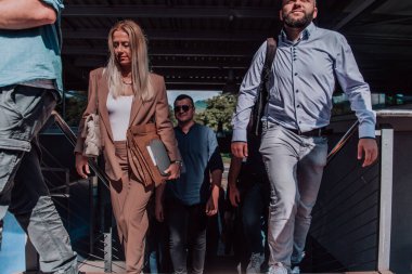 Çeşitli iş adamları ve meslektaşları iş yerlerinin yanından birlikte yürüyorlar, şirkette işbirliği ve takım çalışması sergiliyorlar.