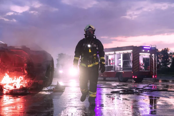 一个穿着防护服的英勇消防员的画像 消防队员在黄昏或夜间进行消防或车祸救援行动 高质量的照片 — 图库照片