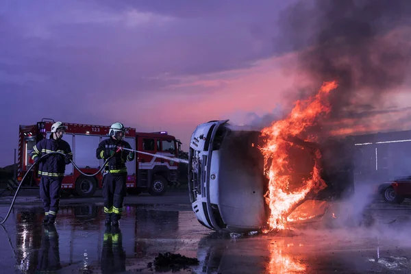 車の事故で火災の炎と戦うために消火器を使用して消防士 夜間の消防産業と公共の安全の概念救助 高品質の写真 — ストック写真