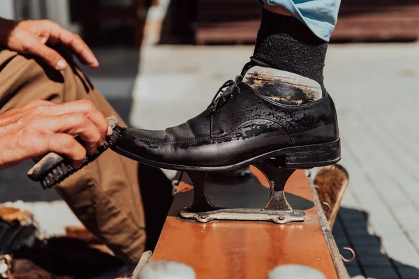 ストリートで黒い靴を研磨し 塗装老人の手 — ストック写真
