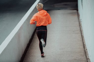 Modern bir şehir ortamında spor elbiseli kadınlar koşuyor. Sportif ve sağlıklı yaşam tarzı kavramı. 