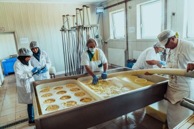 Arab business partners oversee cheese production in modern industry. 