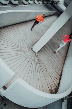 Two women in sports clothes running in a modern urban environment. The concept of a sporty and healthy lifestyle. 